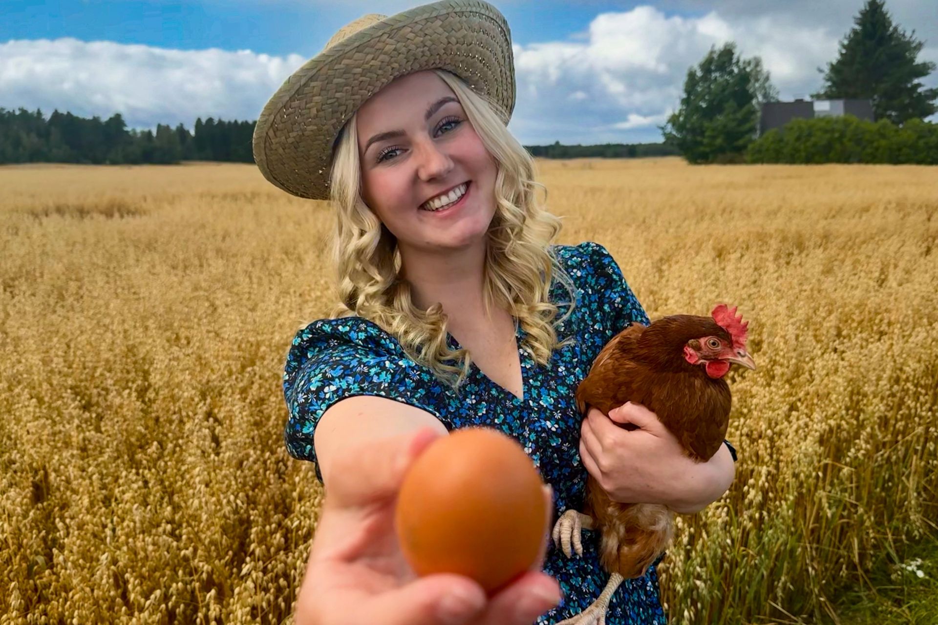 Nainen pellolla, kana sylissä